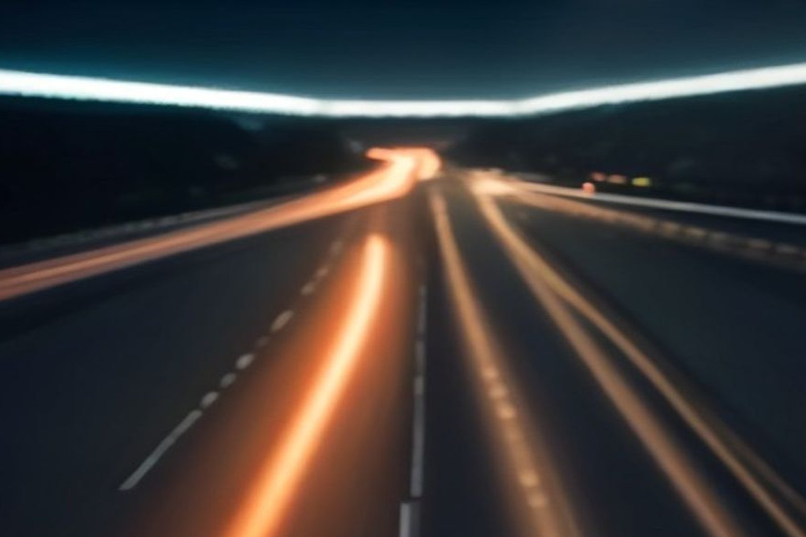 A blurred city road at night with light trails